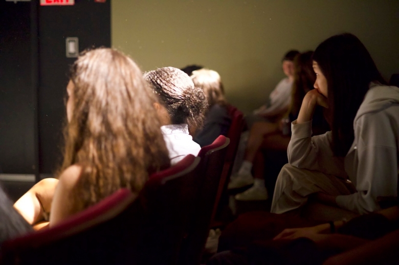 Photo taken behind students sitting in a Tisch classroom auditorium